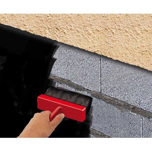 Applicazione di guaina liquida su un muro di mattoni con un pennello.
