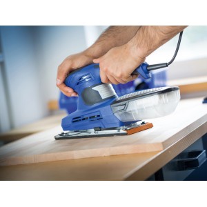 Levigatrice orbitale blu LUX in uso su una superficie di legno. Abrasivi per levigatura fine.