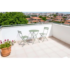 Set di mobili da giardino t.b.t. verde con tavolo e due sedie su una terrazza.