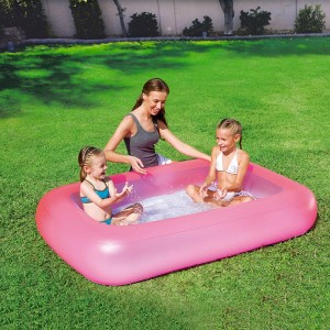 Piscina rosa per bambini con bambini che giocano in giardino.