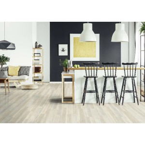Pavimento vinilico chiaro t.b.t. in un moderno spazio abitativo con isola cucina e sedie.
