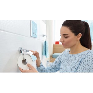 Donna che cambia la carta igienica sul porta carta igienica t.b.t. in bagno.