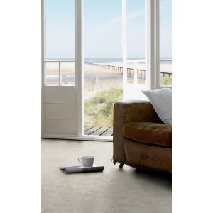Pavimento vinilico chiaro in un soggiorno con vista sulla spiaggia e sul mare.