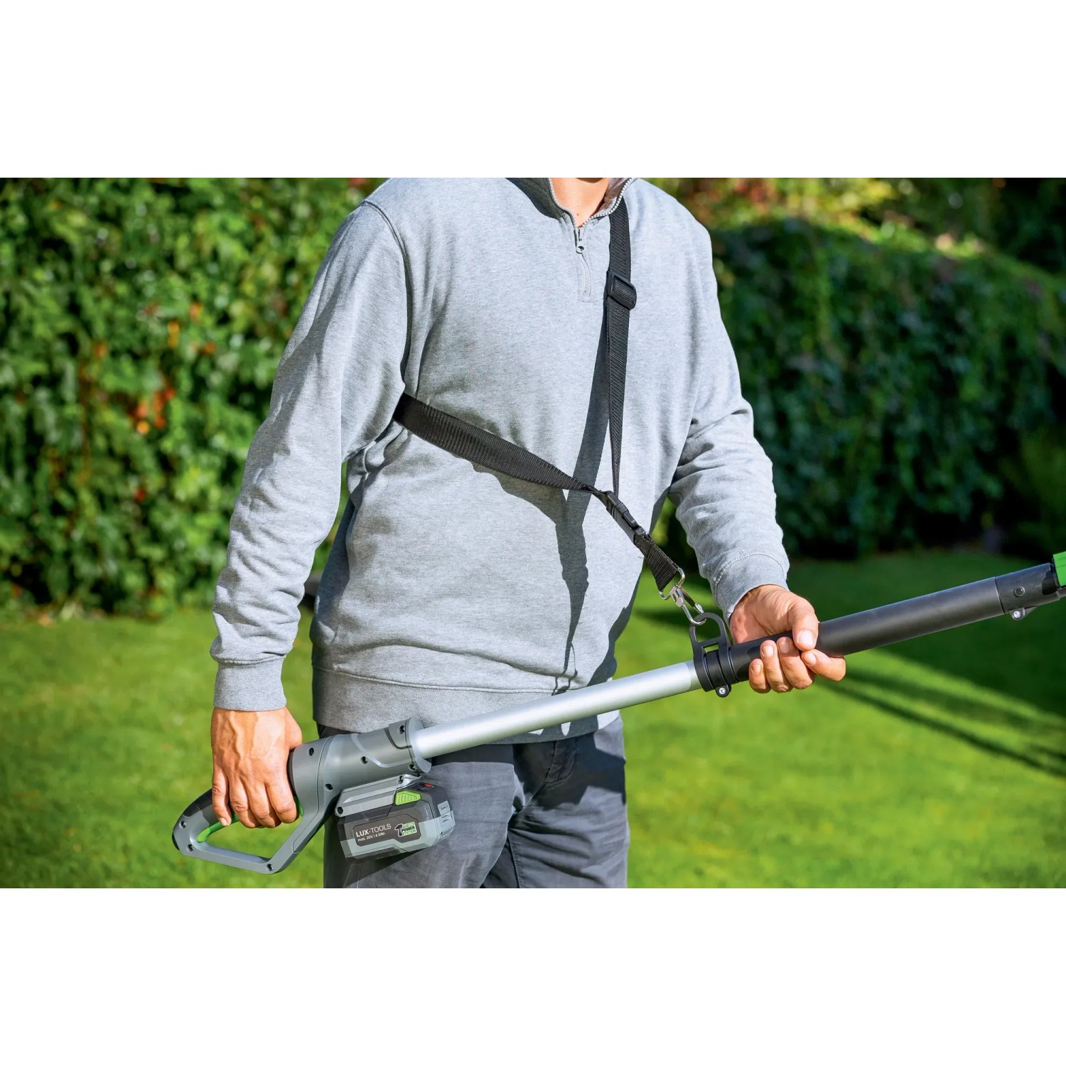 Potatore a batteria t.b.t. con tracolla in azione, ideale per la potatura degli alberi.