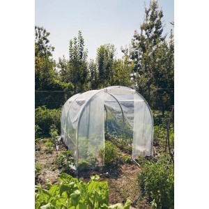 Piccola serra a tunnel trasparente in un giardino.