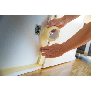 Applicazione di nastro adesivo in carta crespa LUX (50 m x 19 mm) per mascherare una parete per la pittura.