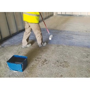 Artigiano dipinge il pavimento con pittura al lattice t.b.t. e rullo. Secchio con vernice pronto.