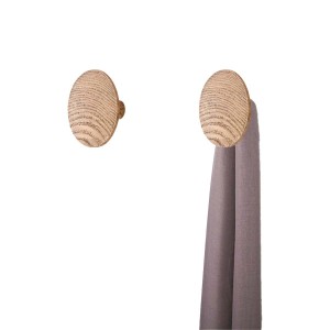 Due ganci a muro rotondi in legno chiaro, uno con un panno grigio. Appendiabiti da parete.