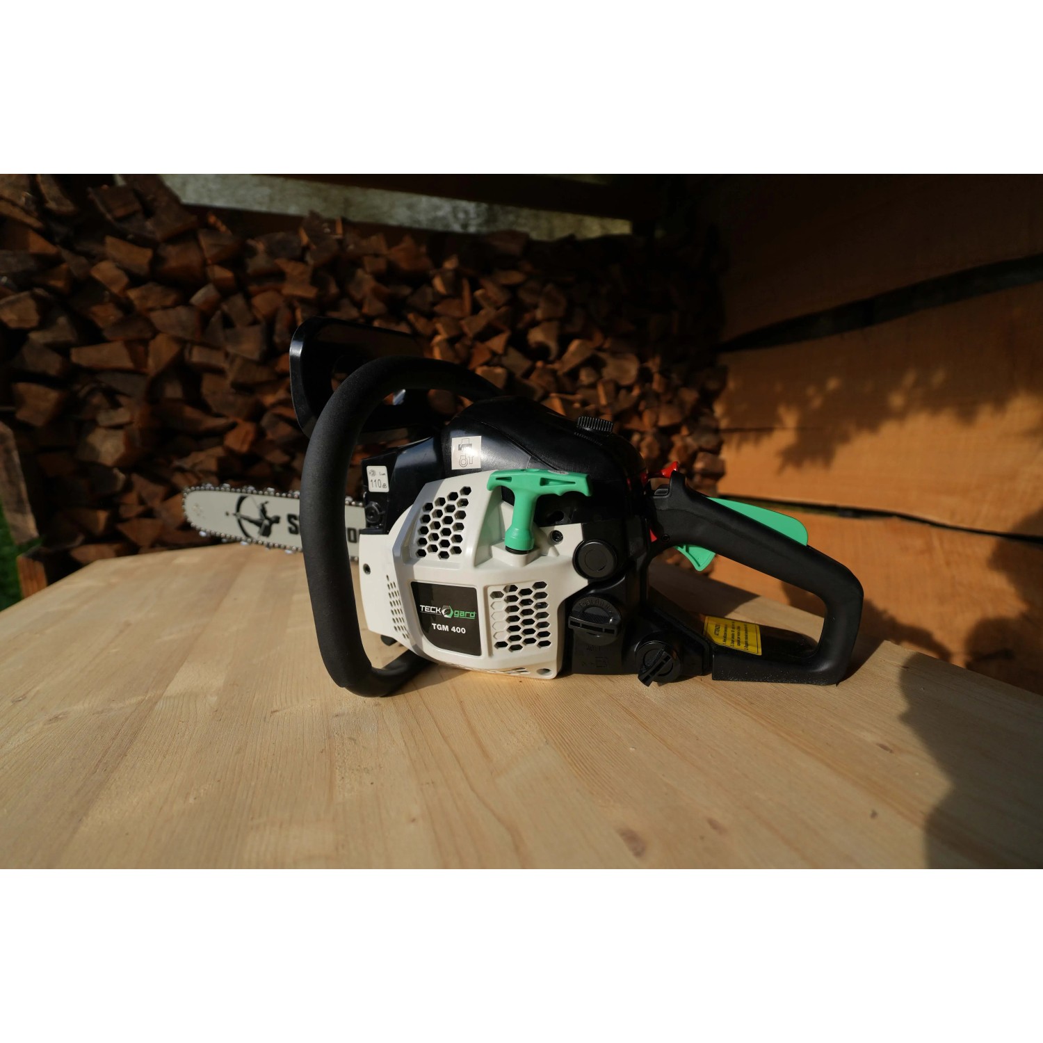 Motosega t.b.t., bianca/nera, su tavolo di legno. Ideale per il giardinaggio.