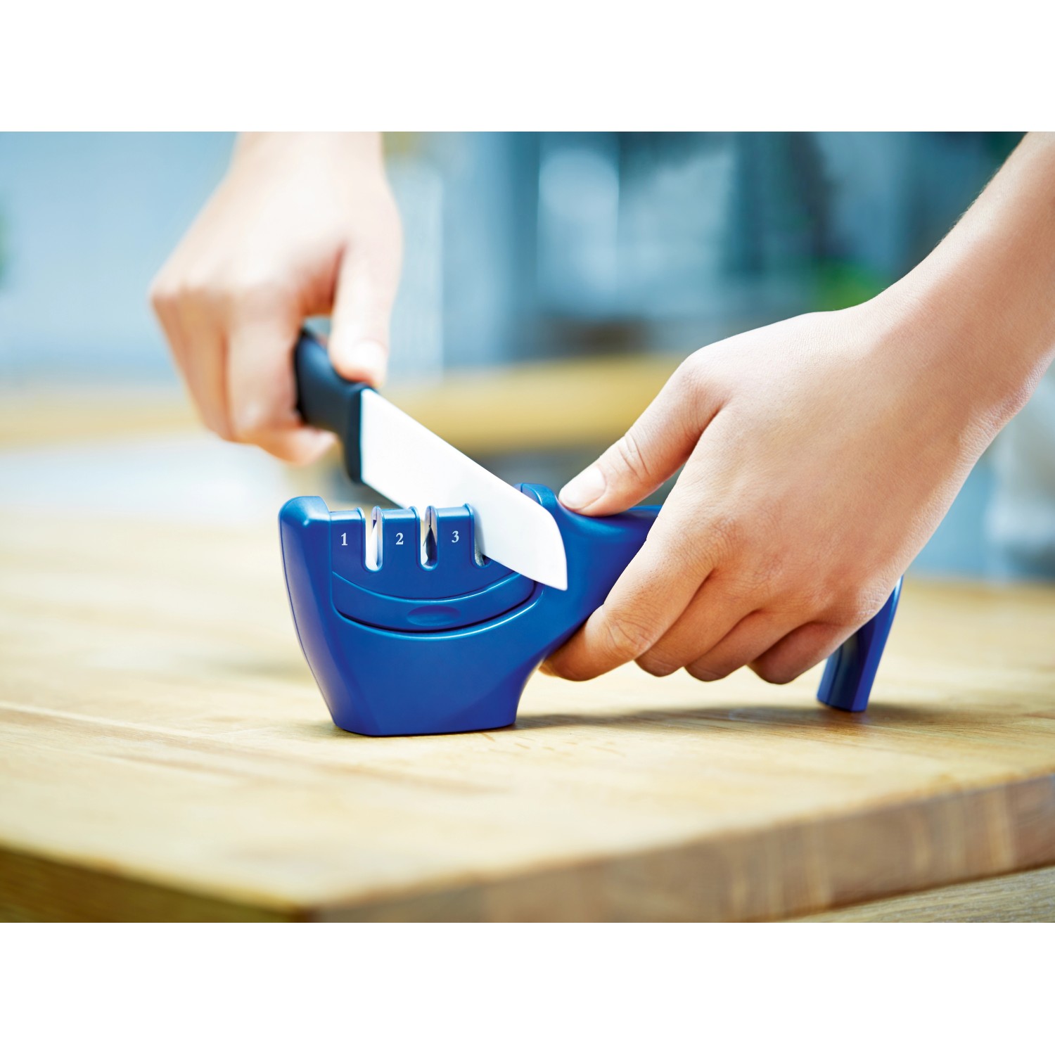 Affilacoltelli LUX in azione: coltello che viene fatto scorrere attraverso il dispositivo di affilatura.