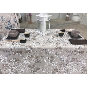 Tovaglia con motivo floreale, tavola apparecchiata con stoviglie e decorazioni.