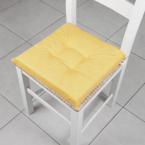 Cuscino per sedia t.b.t. giallo su sedia bianca. Accessorio confortevole per maggiore comodità.