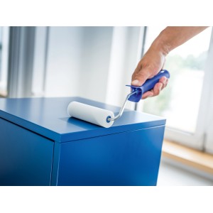 Rullo in schiuma LUX (11 cm, bianco, 5 pz.) mentre vernicia una superficie blu.