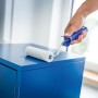 Rullo in schiuma LUX (11 cm, bianco, 5 pz.) mentre vernicia una superficie blu.
