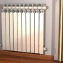 Radiatore argentato con elementi multipli montato a parete.