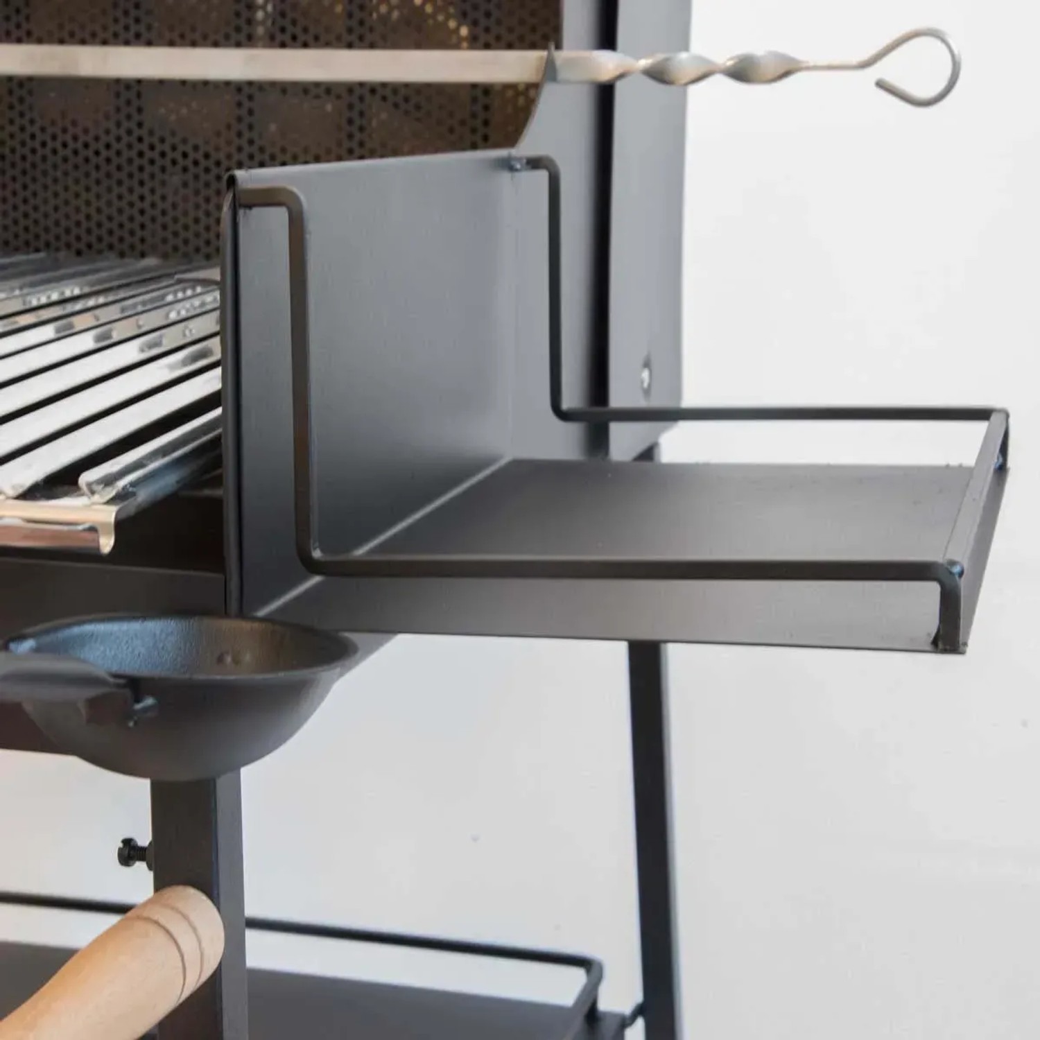 Dettaglio del barbecue a carbonella t.b.t. con ripiano e accessori.