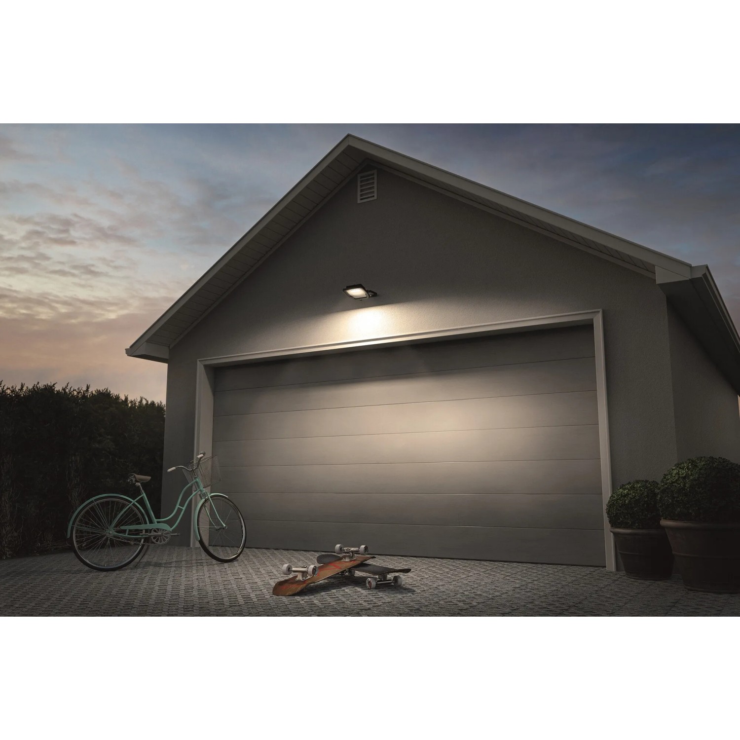Faretto LED da esterno Ledvance Endura Flood 20W grigio scuro su garage, illuminato con luce bianca fredda.