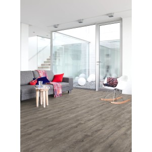 Pavimento vinilico Gerflor effetto rovere 2 mm posato in soggiorno con divano e sedia.