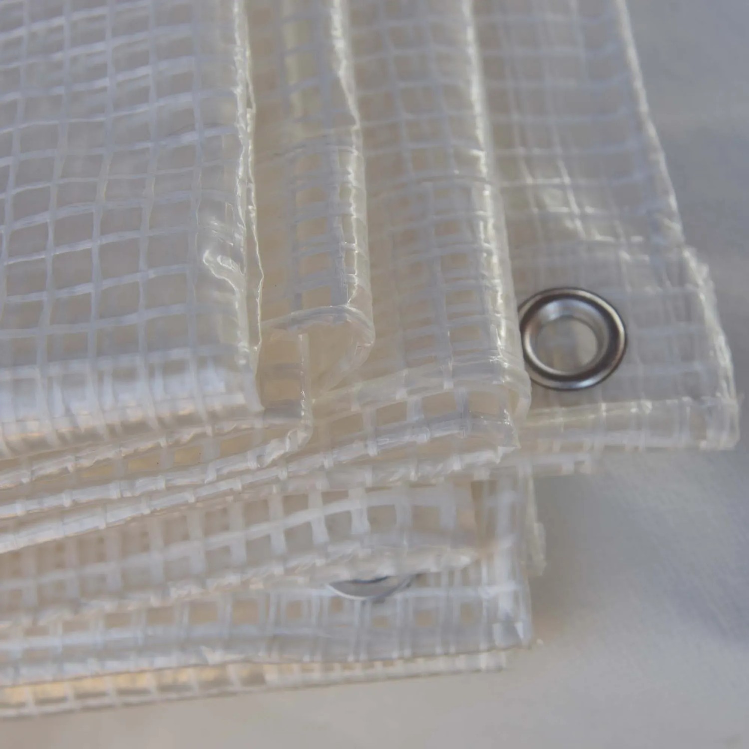 Telone di copertura trasparente con occhielli, ideale per la protezione dagli agenti atmosferici.