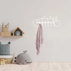 Organizzatore da parete a forma di bicicletta bianca con asciugamano in una stanza dei bambini.