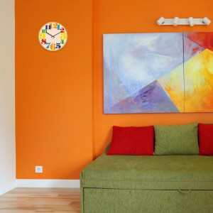 Orologio da parete con numeri colorati in un soggiorno. Elemento decorativo per la cameretta dei bambini o la cucina.