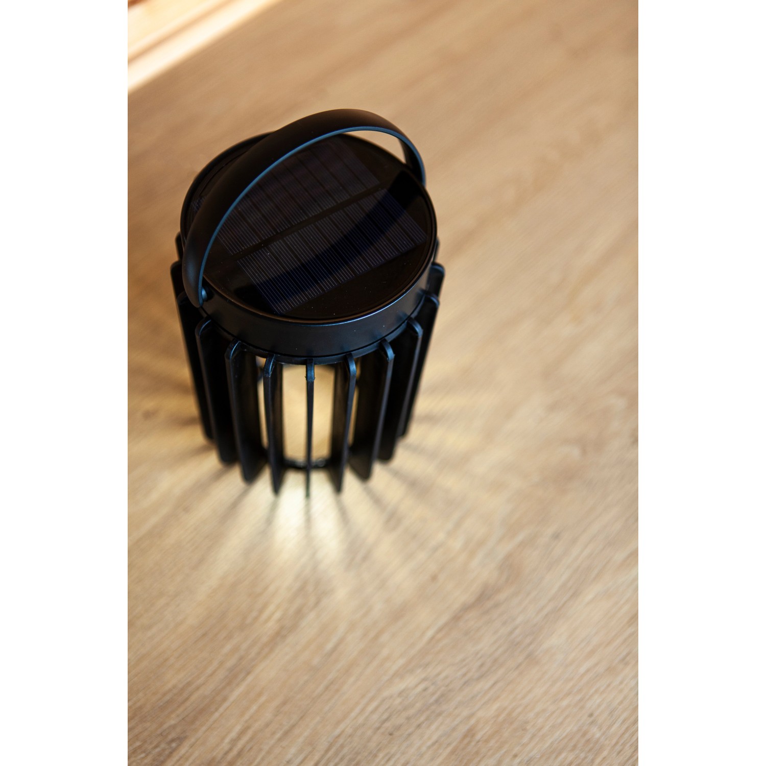 Lampada da tavolo solare a LED Lutec Kozy nera con struttura a griglia e maniglia.