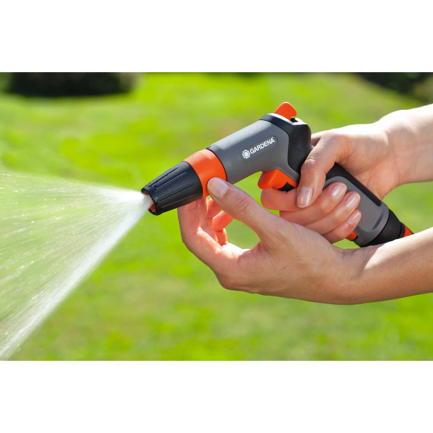Gardena Pistola per pulizia Classic in azione: Pistola da giardino grigia con getto d'acqua in mano.
