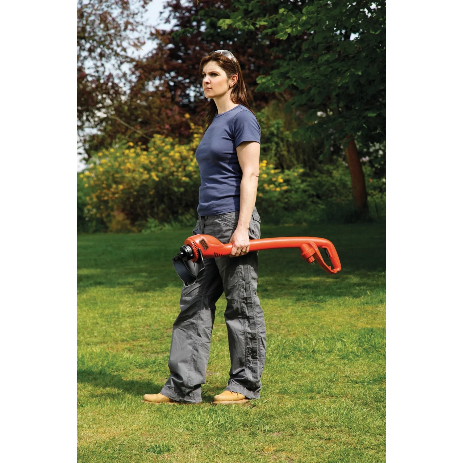 Donna con tagliaerba elettrico Black+Decker GL250 in giardino.