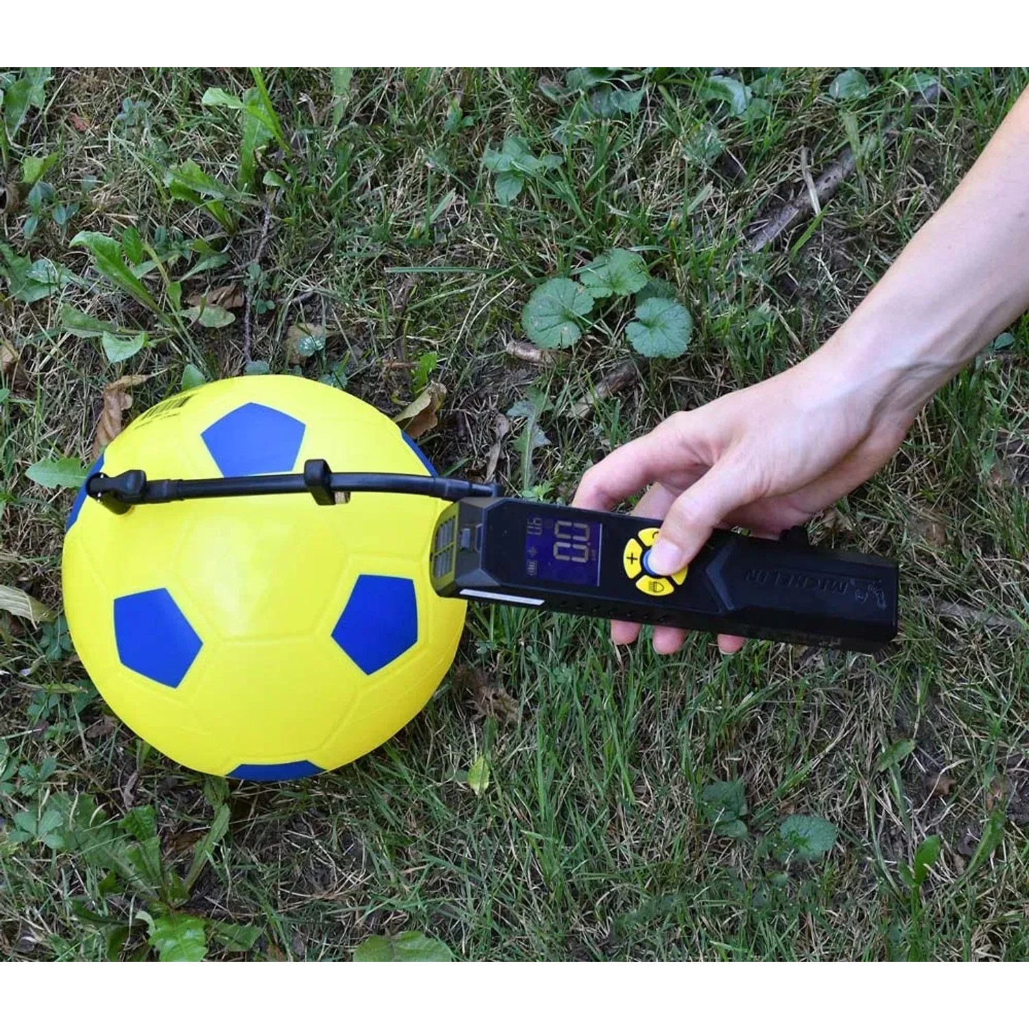 Pallone da calcio giallo-blu gonfiato con un manometro digitale.