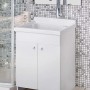 Mobile lavabo bianco con rubinetto e specchio in bagno.