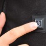 Primo piano: dito preme il pulsante di accensione sull'abbigliamento da lavoro t.b.t.