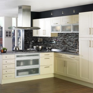Cucina moderna con piastrelle a mosaico come paraschizzi e mobili da cucina chiari.