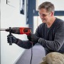 Uomo che fora un muro con il martello perforatore Einhell TC-RH 620 4F Kit.