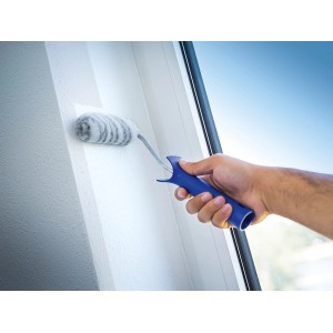 Mano che dipinge parete con rullo per dispersioni LUX 10 cm. Rullo con manico blu.