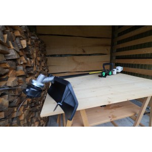 Decespugliatore/tagliabordi su tavolo di legno davanti a parete di legno.