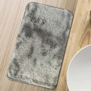 Tappeto a pelo lungo rettangolare grigio su pavimento in legno.