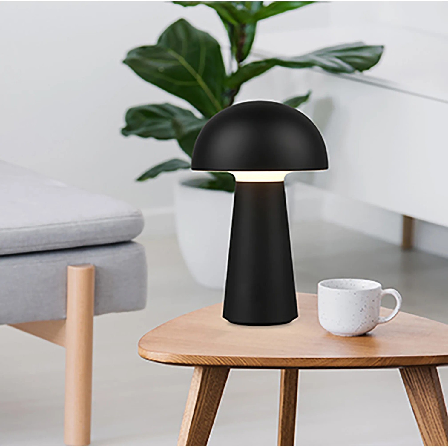 Lampada da tavolo LED Lennon nera a forma di fungo, Ø 13,6 cm, su tavolo di legno.