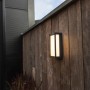 Moderna applique da esterno a LED Lutec Qubo color antracite con 1.000 lm su una parete di legno.