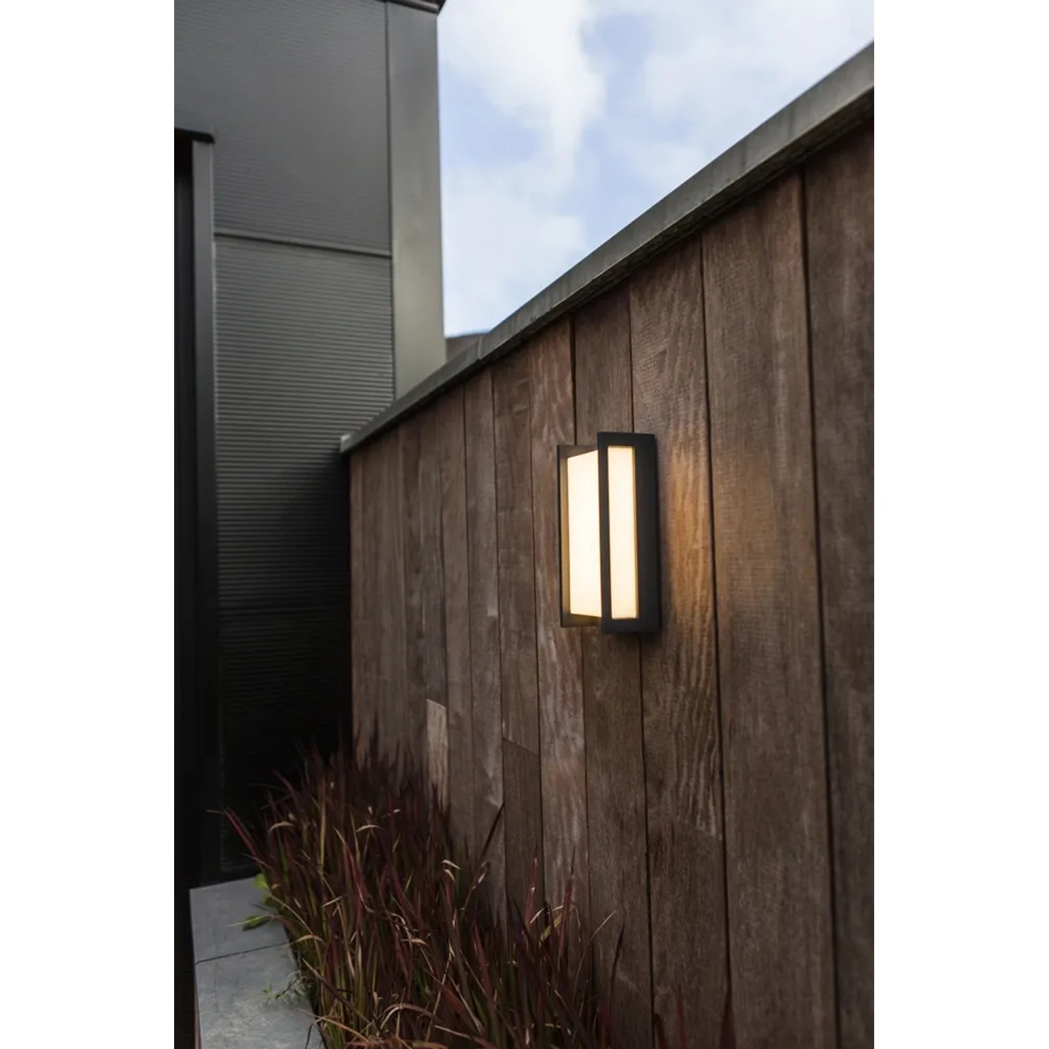 Moderna applique da esterno a LED Lutec Qubo color antracite con 1.000 lm su una parete di legno.