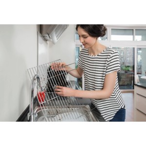 Donna pulisce la griglia con la spirale Vileda Glitzi (confezione da 3) nel lavandino.