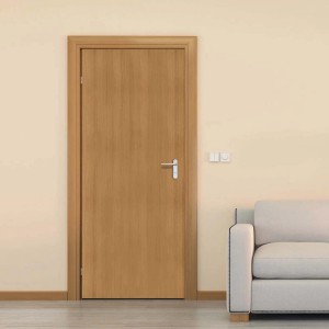 Porta in legno con maniglia argentata su parete beige e divano.