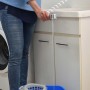 Donna riempie secchio con doccetta t.b.t. Ideale per bagno e cucina.