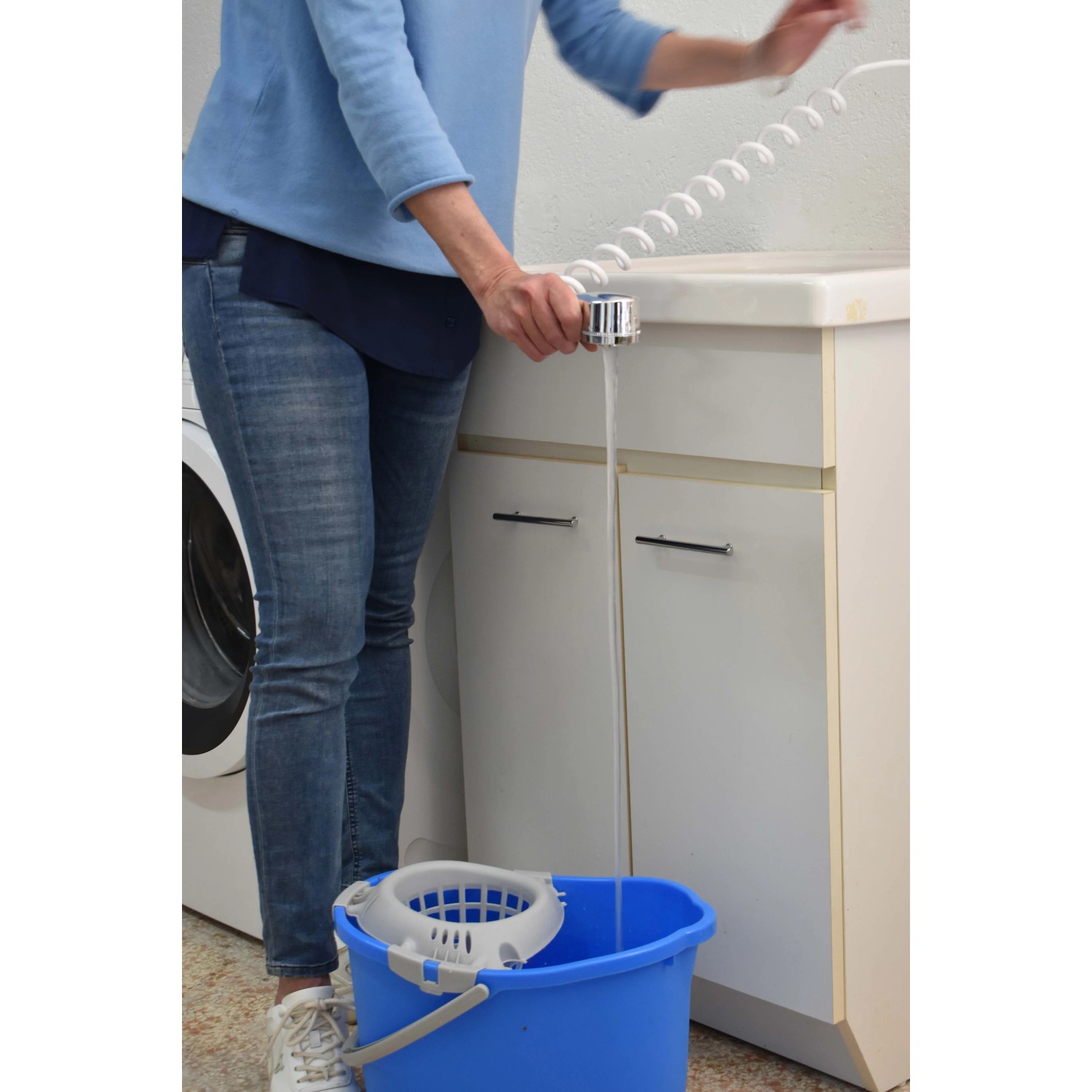 Donna riempie secchio con doccetta t.b.t. Ideale per bagno e cucina.