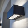 Moderna lampada da parete per esterni a LED Lutec Gemini color antracite montata su una parete.