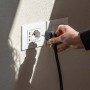 Inserimento di una spina in una presa per un pannello solare da balcone.