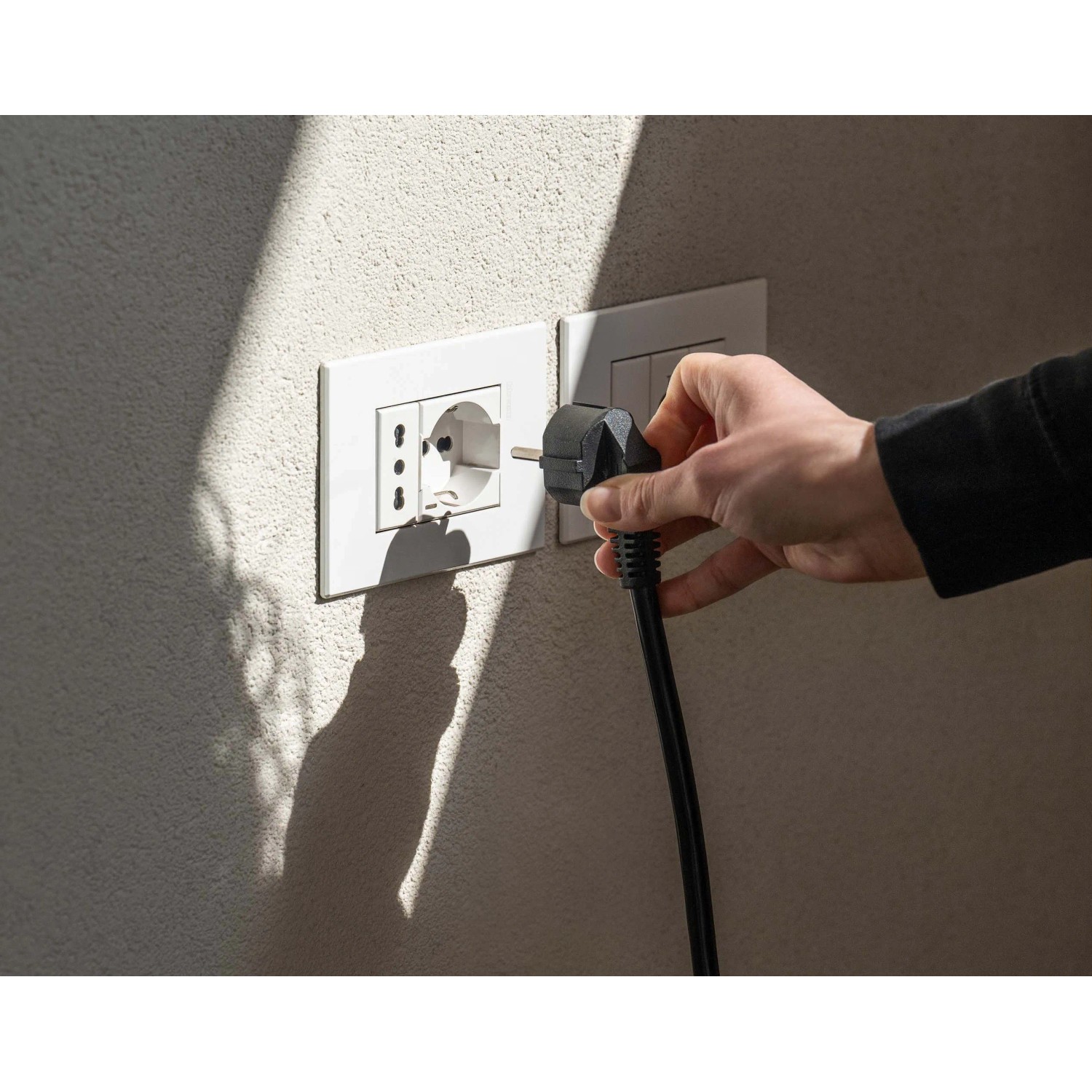 Inserimento di una spina in una presa per un pannello solare da balcone.