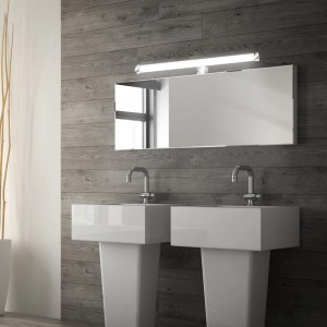Lampada da specchio cromata Briloner Repens IP44 sopra uno specchio e un lavabo.