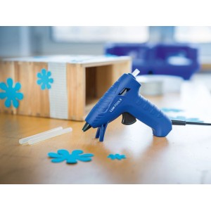 Pistola per colla a caldo LUX 30W Classic con stick di colla e pezzo in lavorazione su un tavolo.