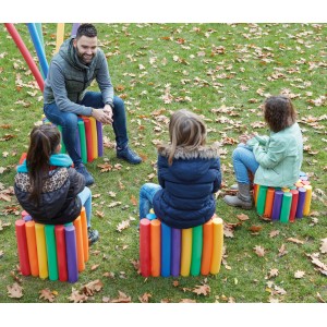 Persone sedute su sgabelli fatti di colorate Comfy noodles da piscina in giardino.