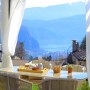 Tavolo all'aperto con cibo e bevande, protezione solare sullo sfondo.